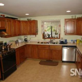 A spacious kitchen featuring wooden cabinets and modern appliances.
