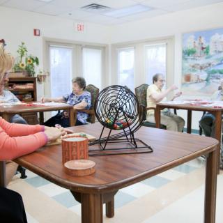A group of seniors playing bingo in a recreational room.