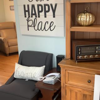 A cozy living room corner with a chair, side table, and decor.