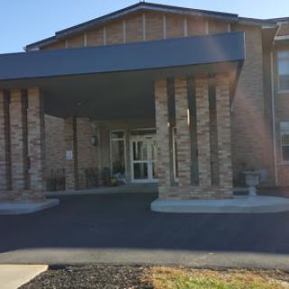 A welcoming entrance to a residential building with stone pillars.