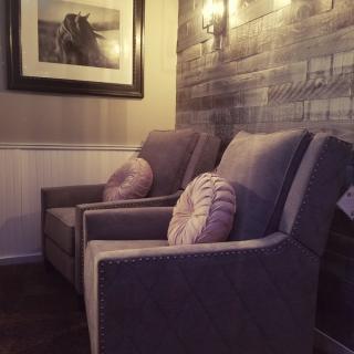 A cozy corner with two comfortable chairs, decorative pillows, and elegant wall art.