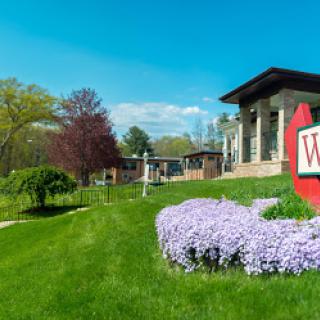 A beautiful spring day showcasing the vibrant flowers and modern architecture of a welcoming building.