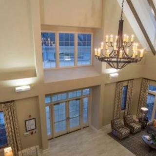 Spacious lobby with a grand chandelier and comfortable seating.