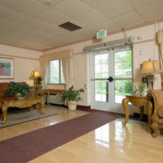 A well-decorated lobby area with elegant furniture and plants near a glass entrance door.