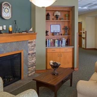A cozy living room featuring a fireplace, bookshelf, and comfortable seating area.