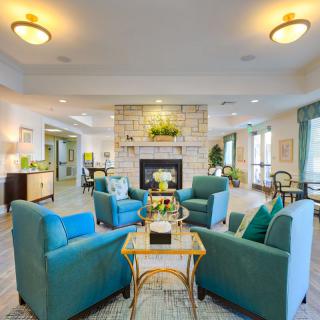 A modern living room with comfortable seating and a central fireplace.