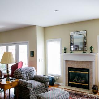 A cozy living room with a fireplace, armchair, and sofa, featuring elegant decor.