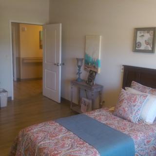 A cozy bedroom with a neatly made bed, decorative pillows, and stylish furniture.