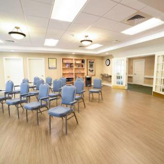 An empty meeting room with rows of chairs arranged for a conference.