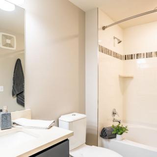 A modern and clean bathroom featuring a bathtub, sink, and mirror.