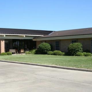 A suburban building with a neatly maintained lawn and clear blue sky.