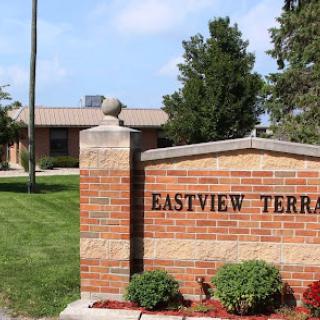 Entrance sign for Eastview Terrace, showcasing well-maintained landscaping and the main building.