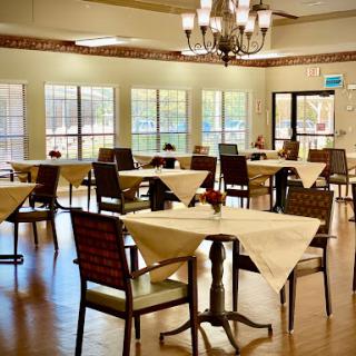 A spacious and well-lit dining area featuring elegantly set tables and comfortable chairs.