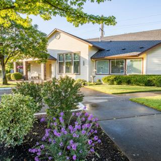A charming residential house with a well-maintained garden and driveway.