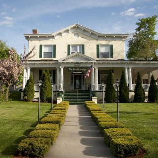 A beautiful two-story house with a well-maintained garden path leading to the front porch.