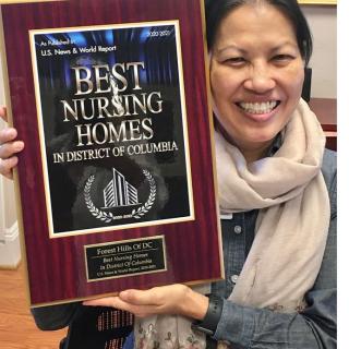 A woman smiling and holding a plaque for Best Nursing Homes in District of Columbia.