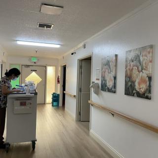 A hospital hallway with medical staff and artwork on the walls.