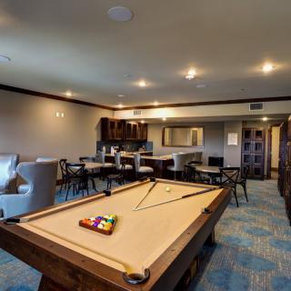 A spacious game room with a pool table and seating area.