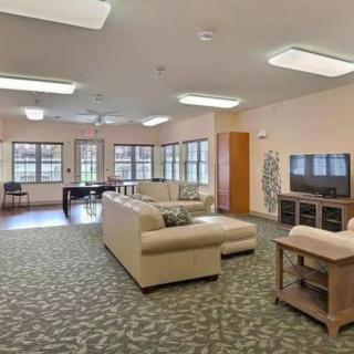 A spacious living room with modern furniture and large windows.