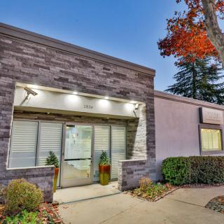 A modern building entrance with well-maintained landscaping in the evening.