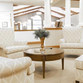 A cozy and elegant living room with plush chairs and a central wooden table.