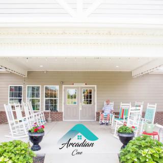 A welcoming front porch with rocking chairs and potted plants at the entrance.