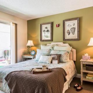 A cozy bedroom with elegant decor, featuring a neatly made bed and warm lighting.