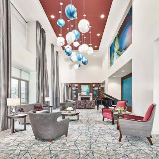 A modern lobby with stylish furniture and unique chandeliers.