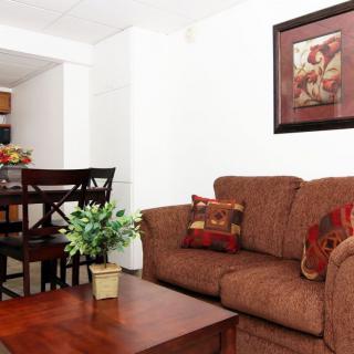 Cozy living room with a brown sofa, wooden coffee table, and dining area in the background.