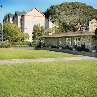A serene outdoor space featuring a well-maintained lawn and buildings in the background.