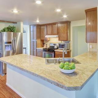 Modern kitchen with wood cabinets and stainless steel appliances.