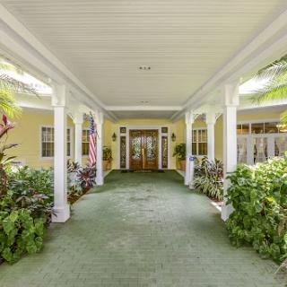 A welcoming entrance with lush greenery and elegant columns.