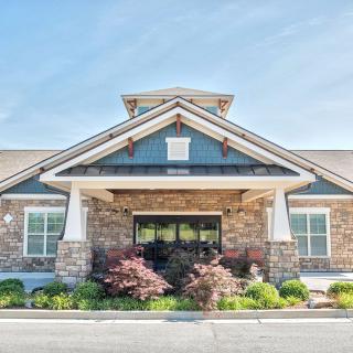 A residential building with a stone facade and well-maintained landscaping.