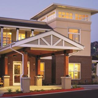 A well-lit building entrance at dusk, showcasing modern architecture.