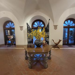 A beautifully designed interior space featuring a decorative table with flowers, framed by elegant windows.