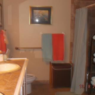 A neatly arranged bathroom with colorful towels and a framed picture on the wall.