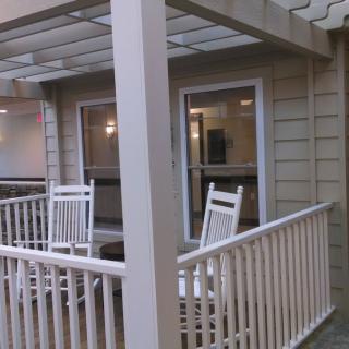 A cozy porch with two rocking chairs and white railings.