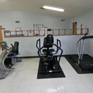 A small gym room with various exercise equipment.