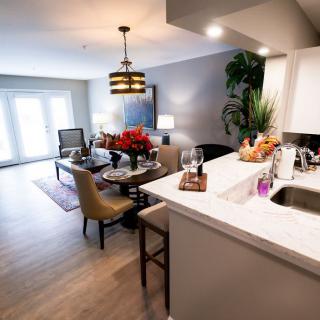 A modern open-concept living space featuring a kitchen, dining, and sitting area with stylish decor and lighting.