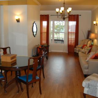 A cozy living and dining area with warm lighting and wooden flooring.