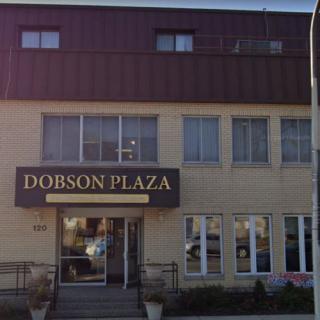 The front view of Dobson Plaza, featuring its entrance and windows.