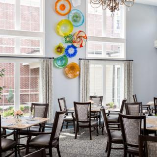 A modern dining room with decorative wall art and elegant furnishings.