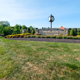 A scenic view of a clock tower surrounded by well-maintained gardens and landscaping.