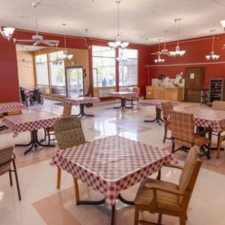 A cozy restaurant dining area with checkered tablecloths and chandeliers.