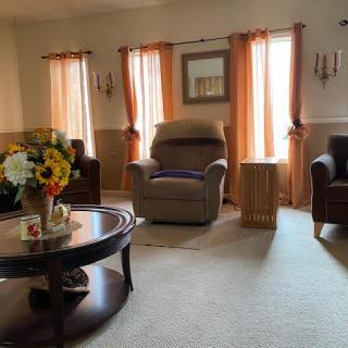 A cozy living room with comfortable armchairs and a coffee table adorned with flowers.