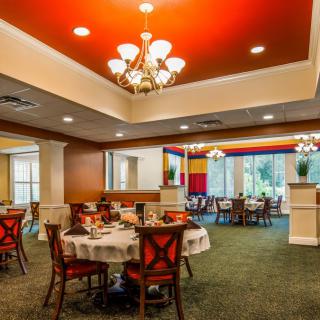 A spacious restaurant dining area with elegantly set tables and warm lighting.