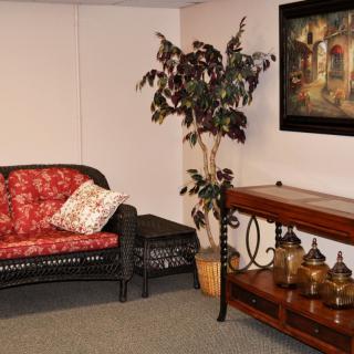 A cozy living room corner with a sofa, indoor plant, and decorative items on a console table.