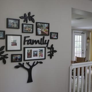 A family-themed photo gallery displayed on a wall with decorative picture frames.