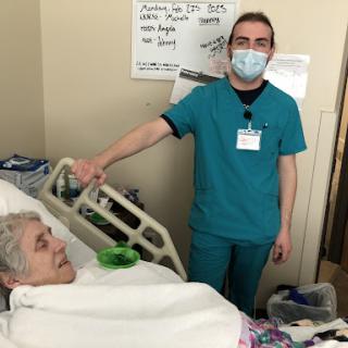 A healthcare worker assisting a patient in a hospital setting.
