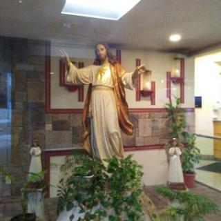 A serene statue of Jesus Christ displayed in a peaceful interior setting.